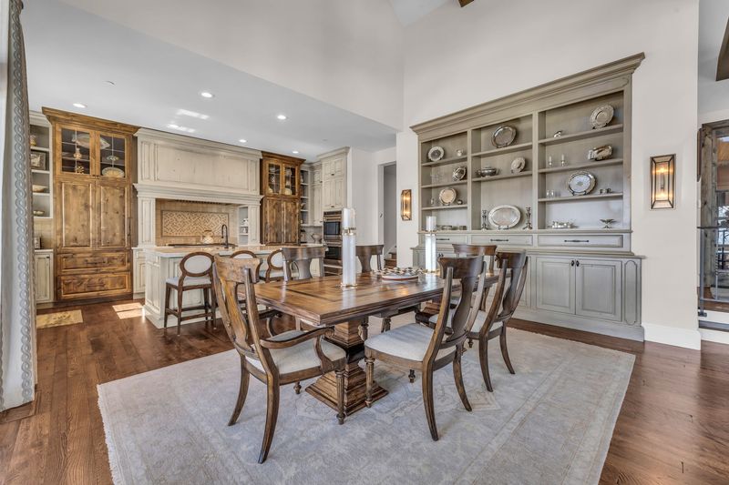 Dining room with a wood table, built-in hutch and chandelier